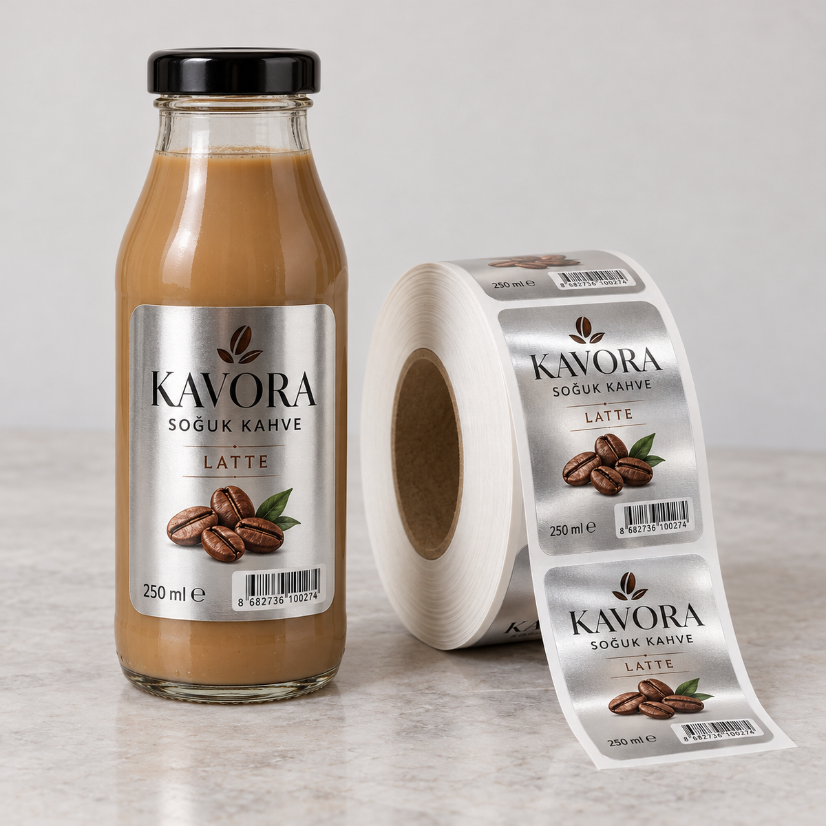 Latte şişesinde kahve çekirdeği görselleri ve barkod içeren gümüş yüzeyli metalize PP etiket ile aynı tasarıma sahip etiket rulosu.
